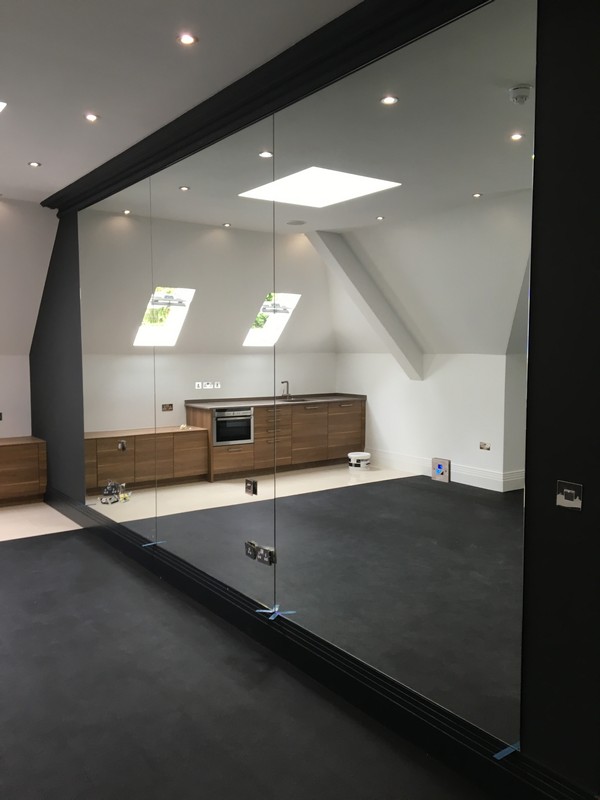 Frameless glass partition in loft conversion by East Sheen glaziers