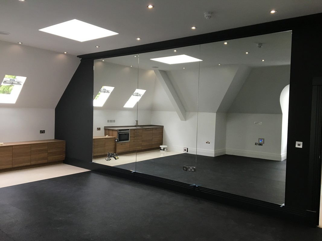 Frameless glass wall dividing loft conversion in East Sheen